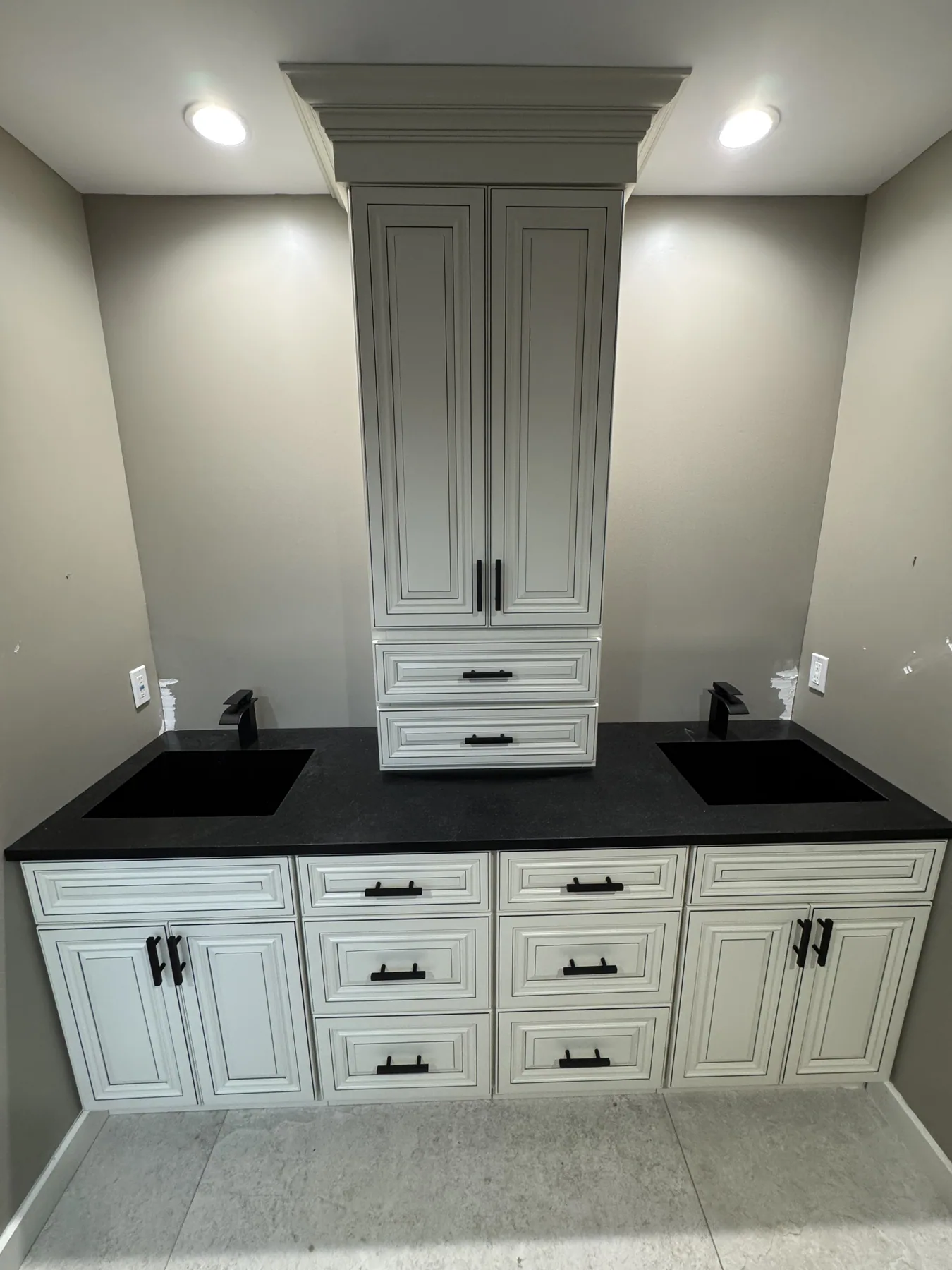Cream cabinetry with black hardware and a stone countertop