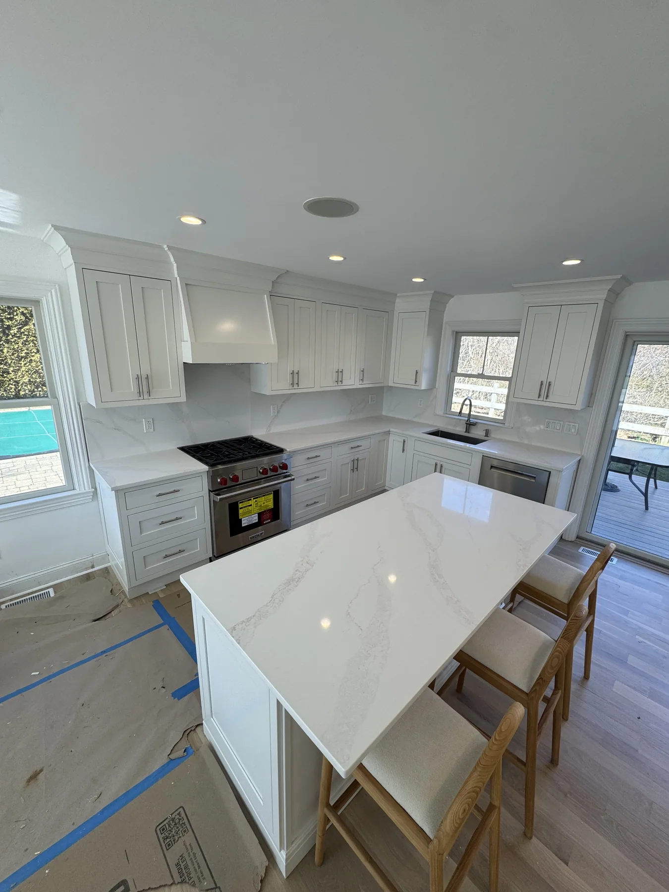 Close view of a white kitchen island with a thick marble countertop
