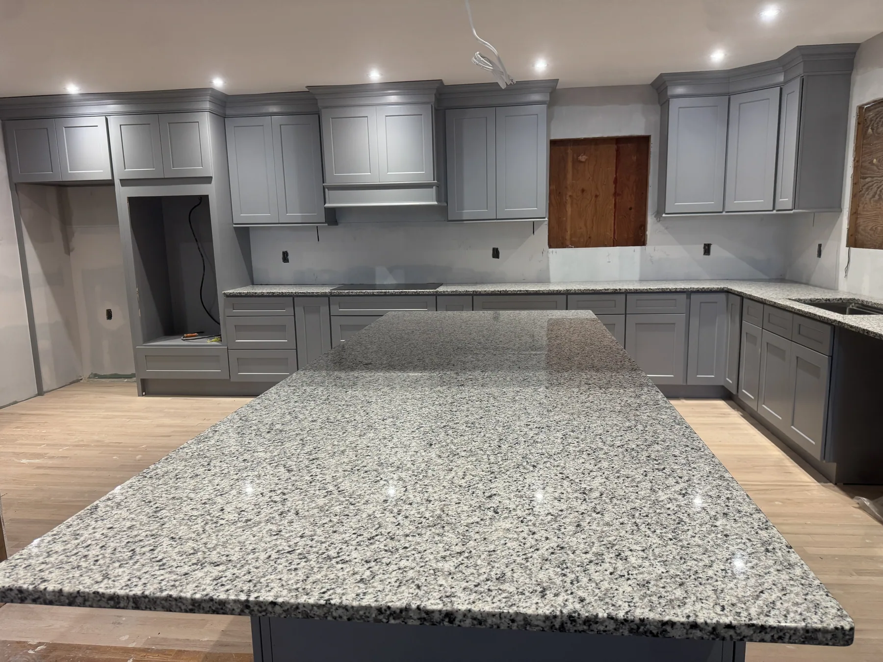 Gray custom kitchen cabinets with granite island countertop